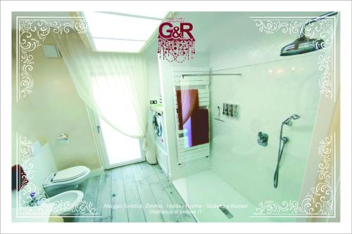 ein Bad mit einer Dusche und einem WC. in der Unterkunft Alloggio Turistico GIULIETTA e Romeo Intero Appartamento Centro Villafranca di Verona, Zimmer, Holiday Rooms in Villafranca di Verona
