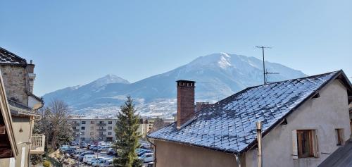 a view of a mountain from a city with a house at L'HIVERNET, grand Triplex neuf au cœur d'Embrun accès facile in Embrun