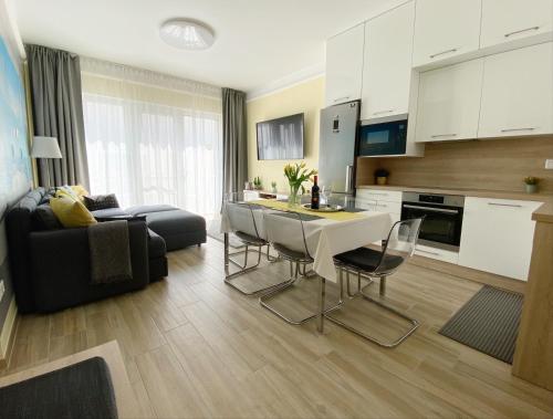 eine Küche und ein Wohnzimmer mit einem Tisch und Stühlen in der Unterkunft NEST2 Apartments in Keszthely