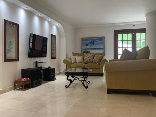 a living room with two couches and a coffee table at Casa Duplex Privada con Piscina with Ride from Airport in Panama City