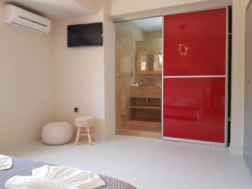 a bedroom with a red sliding door and a bathroom at Villa Diktina with private pool sea view in Tavronitis