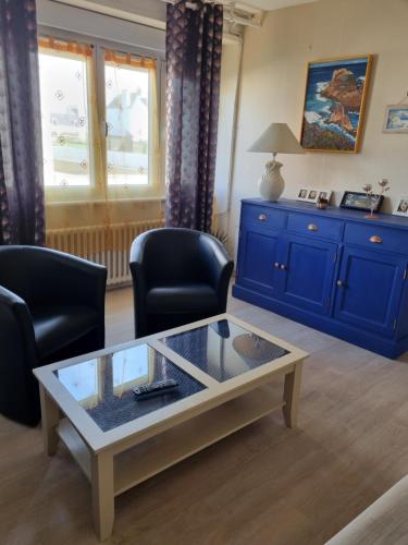 un salon avec deux chaises et une table basse dans l'établissement appartement proche de la mer, au Guilvinec
