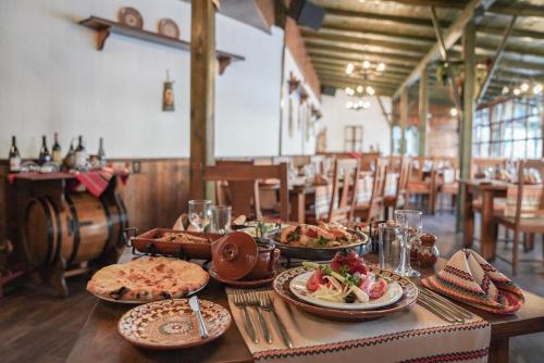 a table with plates of food on it in a restaurant at GRIFID Arabella Hotel - Ultra All inclusive & Aquapark in Golden Sands
