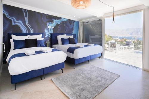 - une chambre avec 2 lits en bleu et blanc dans l'établissement YalaRent Villa Enorma with Private Pool, à Eilat