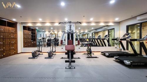 a gym with several treadmills and machines in it at VNAHOMES APARTHOTEL in Hanoi