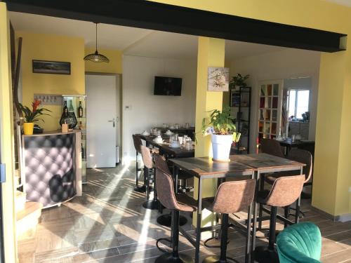 a dining room with a long table and chairs at La Villa Port Winston - Face Mer B&B in Saint-Côme-de-Fresné
