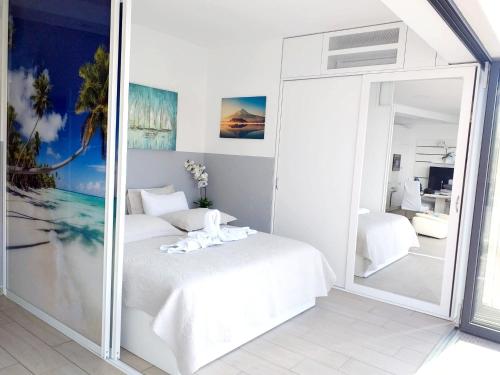 Habitación blanca con cama y espejo en Apartments Palada 1, en Baška