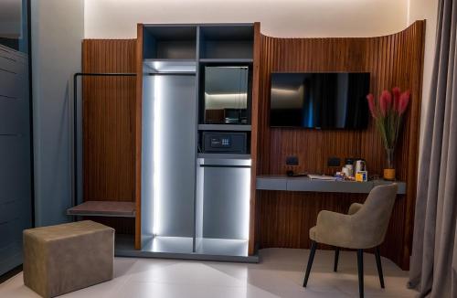 a kitchen with a stainless steel refrigerator and a chair at Best Western Hotel Ferrari in Nola
