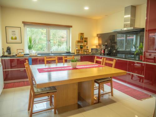 a large kitchen with a wooden table and chairs at Naturena Agro-Turismo in Durrães