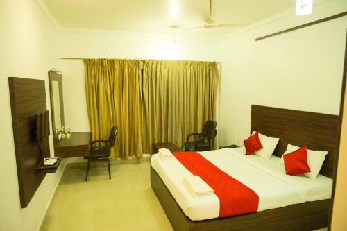 1 dormitorio con 1 cama grande con almohadas rojas en JB Residency en Tiruchchirāppalli
