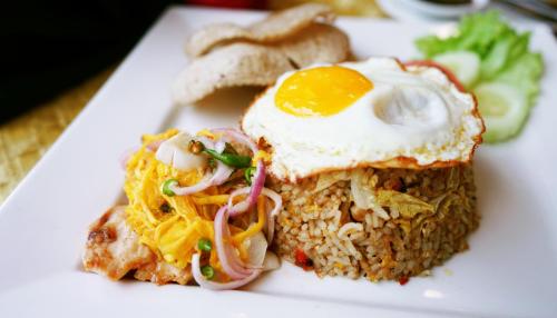 a plate of food with an egg on top of rice at Shahzan Hotel Kuantan, Trademark Collection by Wyndham in Kuantan