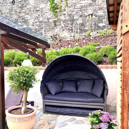 a black couch sitting on a patio with a potted plant at Boutique Apartments Felicino údolí in Vranov nad Dyjí