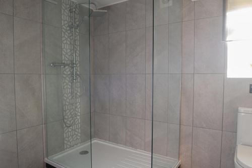 a shower with a glass door in a bathroom at Chocbox Cottage - 2 bedroom chocbox cottage with hottub and log fire in Pocklington