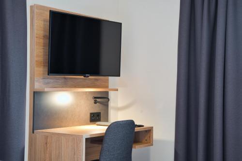 a tv sitting on top of a desk with a chair at Landgasthof Hirschen in Hohentengen