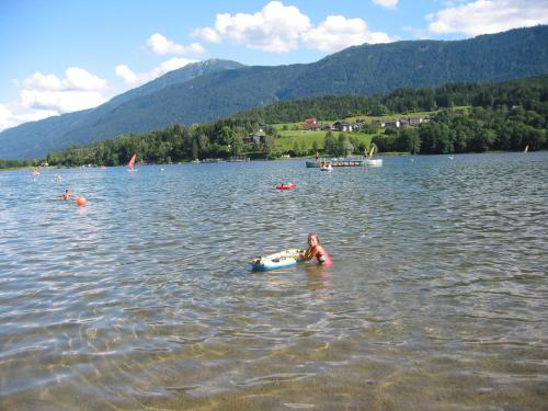a young girl is swimming in a lake at Haus Assinger in Hermagor