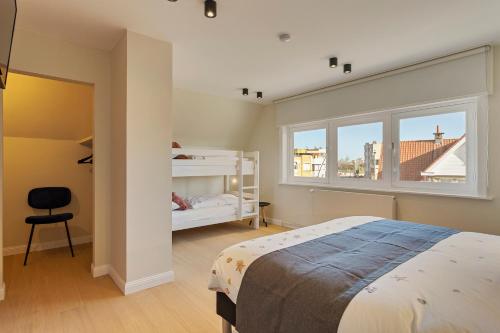 a bedroom with a bed and a window and a chair at Maison Emile in De Panne