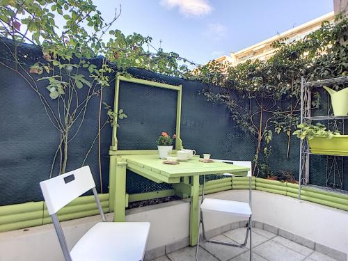 une table et des chaises vertes sur un balcon avec des plantes dans l'établissement Nestor&Jeeves - MARYLIN - Central - Very close sea, à Nice