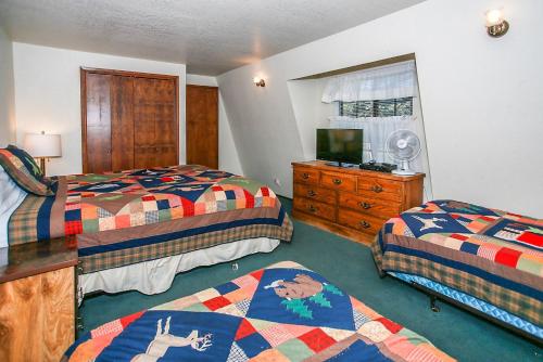 a hotel room with two beds and a television at Breezy Two-113 by Big Bear Vacations in Big Bear Lake