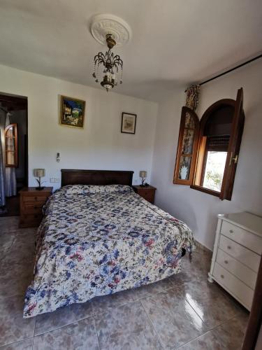 a bedroom with a bed and a chandelier at Casa Rural El Castillo in Málaga