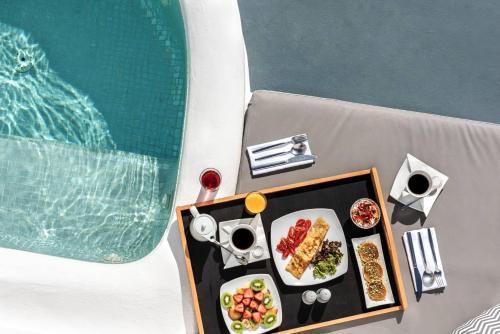 a table with a tray of food on it at La Perla Villas and Suites - Adults Only in Oia
