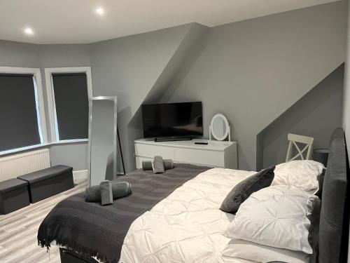 a bedroom with a large bed and a television at Entire spacious 4 bedroom apartment in Bournemouth in Bournemouth