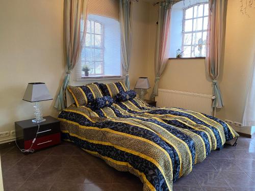 a bedroom with a large bed with a yellow and blue blanket at Natur Hof Fehmarn in Fehmarn