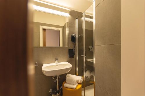 a bathroom with a sink and a mirror at Hi Hotels Trento - Wellness & Spa Adults Only in Trento