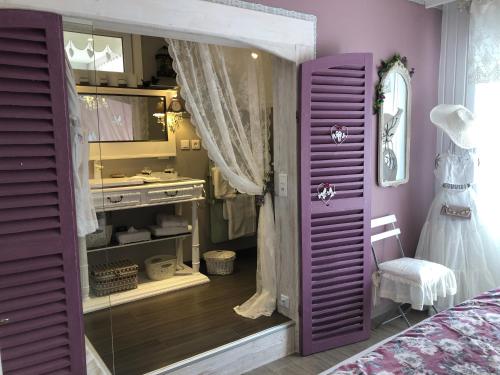 - une porte violette dans une chambre avec une commode et un miroir dans l'établissement Gite Riquewihr "C'est Beau la Vie Alsace", à Riquewihr