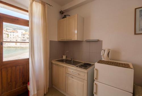 a small kitchen with a sink and a refrigerator at Beachfront Love Nest in Komiža