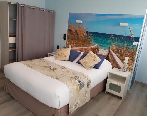 um quarto com uma cama e vista para o oceano em The Originals Access, Hôtel Corinna, Royan em Royan
