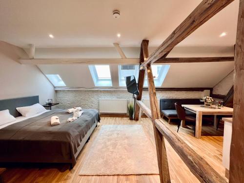 a loft bedroom with a bed and a table at Chalet & Apart Fichtelberger Blick in Kurort Oberwiesenthal