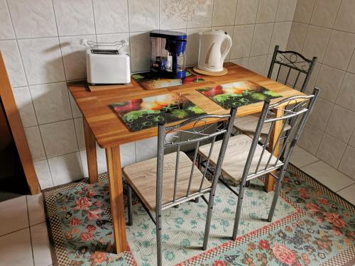 a wooden table with two chairs and a coffee maker at Zimmervermietung Koltermann in Greifswald