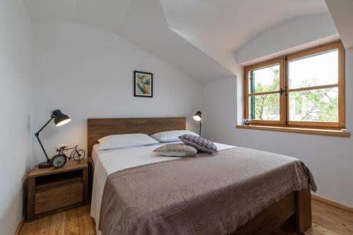 een slaapkamer met een bed en een raam bij Komun Apartments in Vela Luka