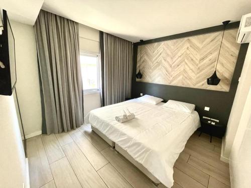 um quarto com uma cama branca e uma janela em Central Business Suites Nicosia By Platform 357 em Nicósia