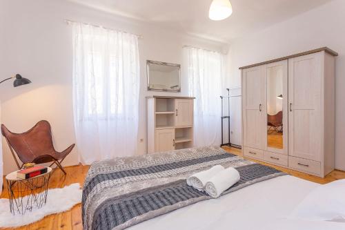 a bedroom with a bed with a cabinet and a tv at Old Market Residence in Šibenik