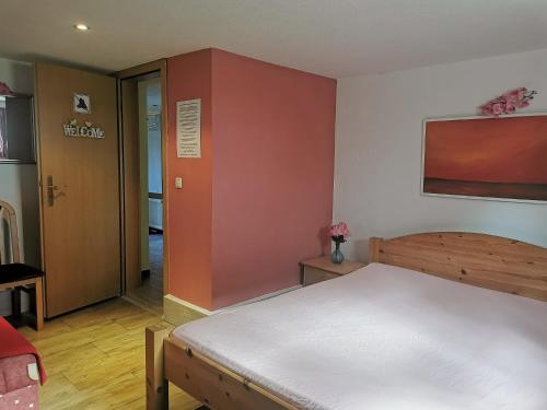 a bedroom with a bed and a red wall at Zimmervermietung Koltermann in Greifswald