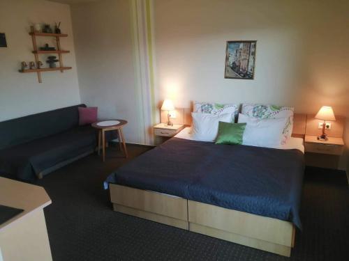 a bedroom with a large bed and a couch at Sweet Apartman Zalakaros in Zalakaros
