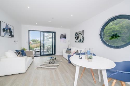 a living room with a white couch and a table at 5 Middlecombe - Luxury Apartment at Byron Woolacombe, only 4 minute walk to Woolacombe Beach! in Woolacombe