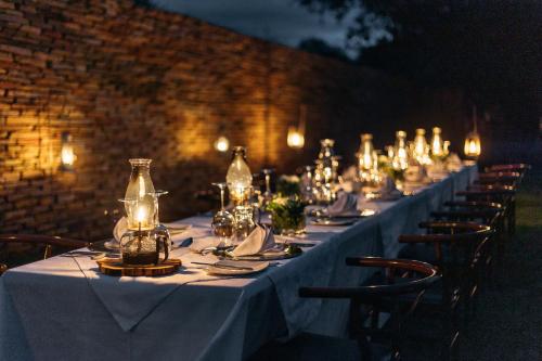 a long table with white table cloth and glass bottles at Karongwe - Becks Safari Lodge in Hoedspruit