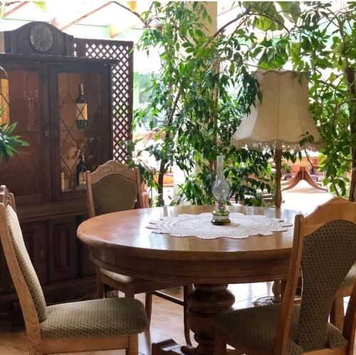 a wooden table with chairs and a lamp on it at Folwark Nadmorska Ostoja in Mechelinki