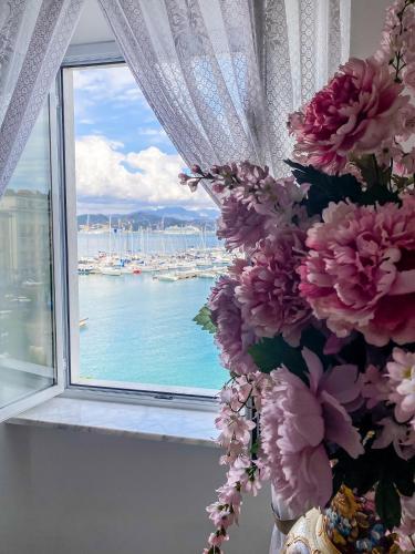 una finestra con vista su un porto con barche di A~Mare Casa Vacanze a Fezzano