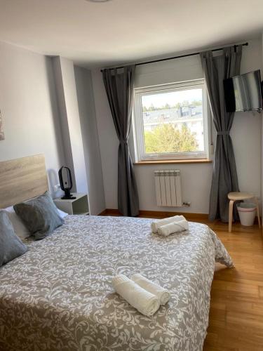 a bedroom with a bed with two towels on it at Pension Ameneiral in O Pedrouzo