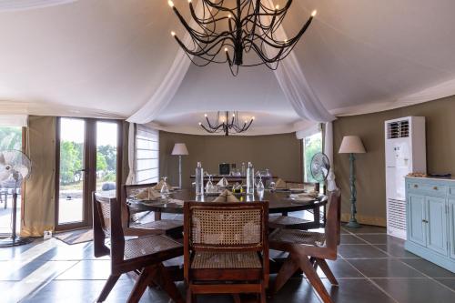a dining room with a table and chairs and a chandelier at The Alampara Resort - Luxury Boutique Glamping & Water sports in Cheyūr