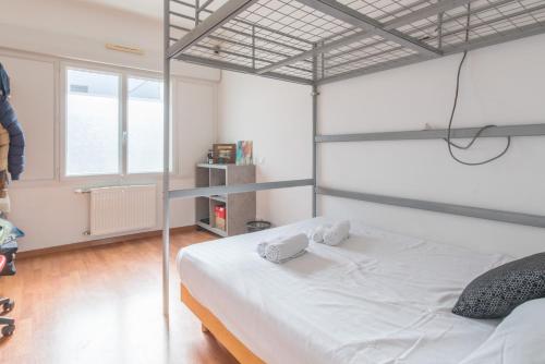 - une chambre dotée d'un lit blanc avec un cadre métallique dans l'établissement LES CELTES - Appartement pour 6, à Saint-Nazaire