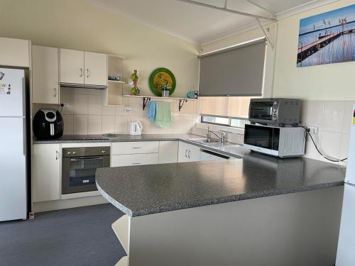 a kitchen with white cabinets and a black counter top at Peter's Port in Pine Point