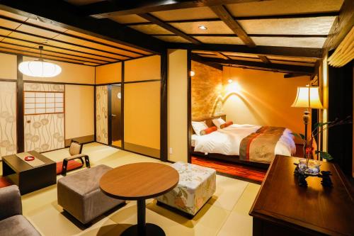 a hotel room with a bed and a table at Kinosaki Tenboen in Toyooka