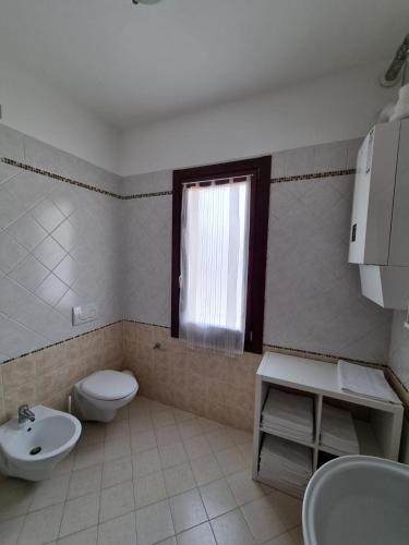 a bathroom with a toilet and a sink and a window at Marzan 12 in Peschiera del Garda