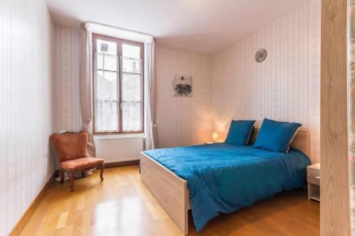 um quarto com uma cama azul e uma cadeira em Le Papillon em Cosne Cours sur Loire