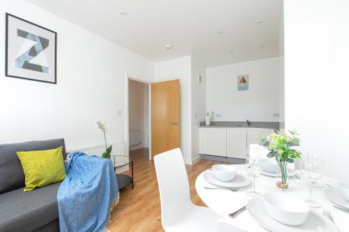 a living room with a white table and a couch at Skyvillion - COZY APARTMENTS in Enfield Town With Free Parking & Wifi in Enfield