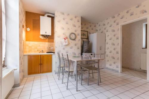 une cuisine avec une table, des chaises et un réfrigérateur dans l'établissement Le Papillon, à Cosne Cours sur Loire